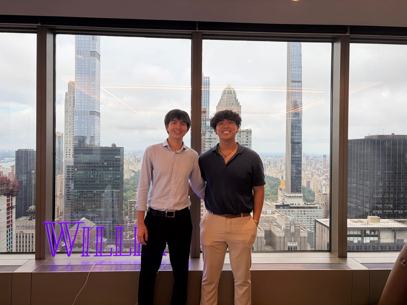Connor and a colleague in front of a Willkie office window overlooking Central Park